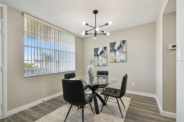 5095 Bay St NE Unit 306, Saint Petersburg, FL 33703 - dining space featuring baseboards, an inviting chandelier, a textured ceiling, and wood finished floors