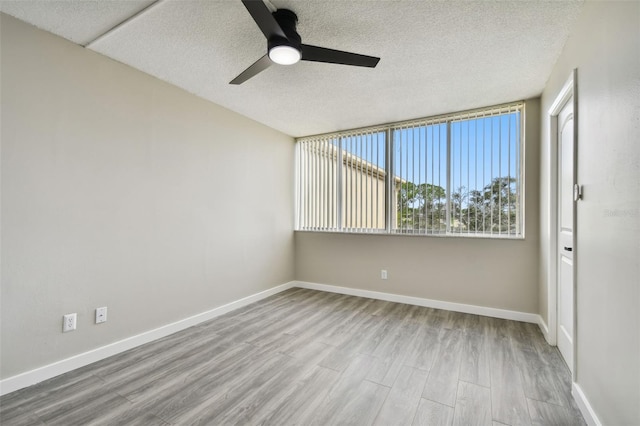 5095 Bay St NE Unit 306, Saint Petersburg, FL 33703 - spare room featuring a ceiling fan, baseboards, a textured ceiling, and wood finished floors