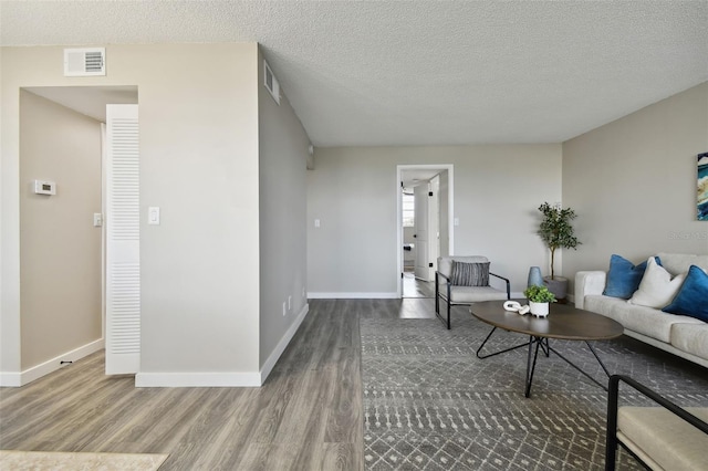 living room with a textured ceiling and hardwood / wood-style floors