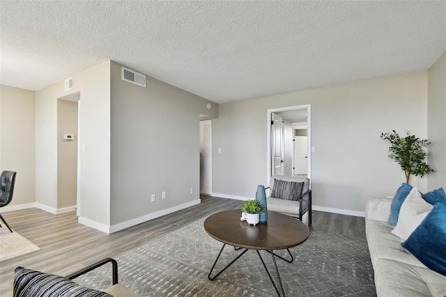 living room featuring hardwood / wood-style floors and a textured ceiling