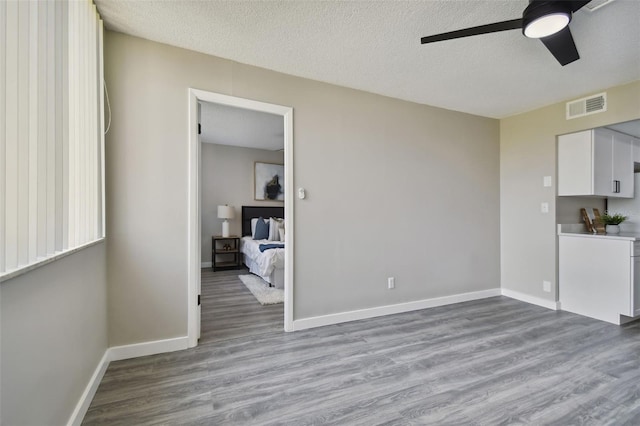 interior space featuring ceiling fan, hardwood / wood-style flooring, and a textured ceiling