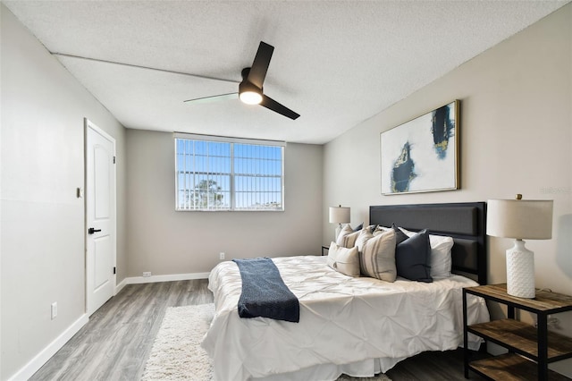 5095 Bay St NE Unit 306, Saint Petersburg, FL 33703 - bedroom with baseboards, a ceiling fan, a textured ceiling, and wood finished floors