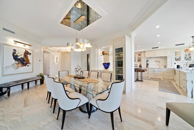 dining area featuring ornamental molding, sink, and a notable chandelier