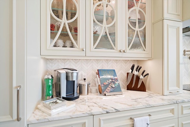 bar featuring light stone counters and backsplash