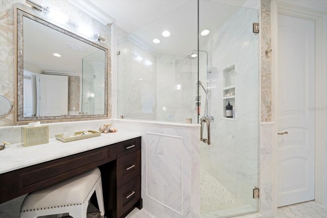 bathroom with tile walls, a shower with door, and vanity