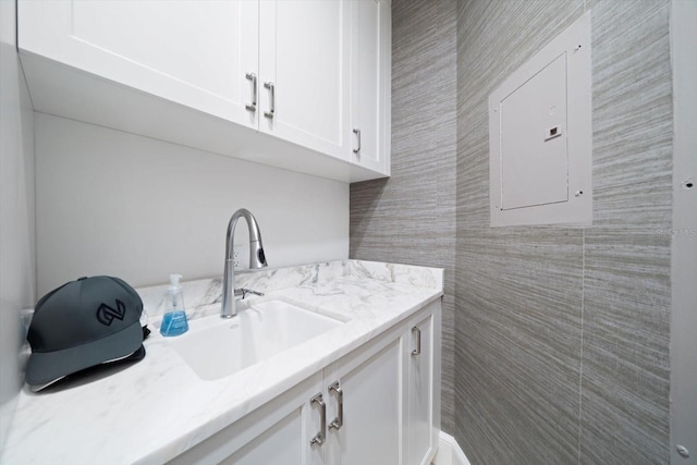 interior space with tile walls, electric panel, and vanity