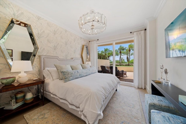 bedroom featuring crown molding, access to exterior, a notable chandelier, and light hardwood / wood-style floors