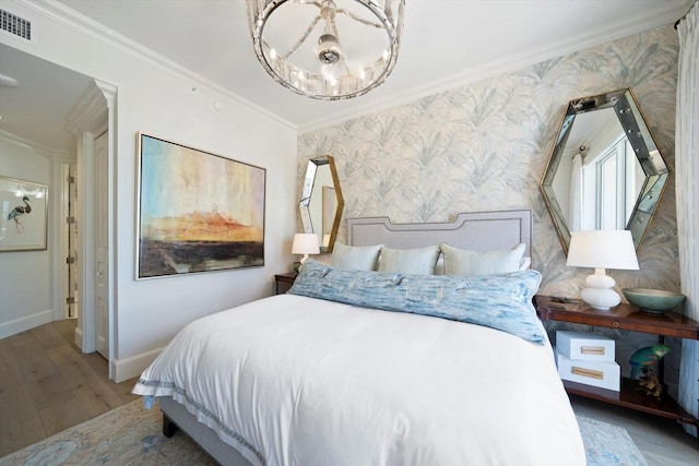 bedroom featuring ornamental molding, wood-type flooring, and an inviting chandelier