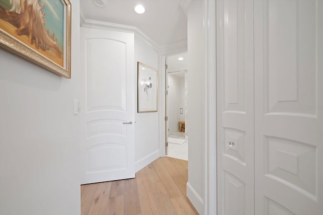 corridor featuring crown molding and light hardwood / wood-style flooring