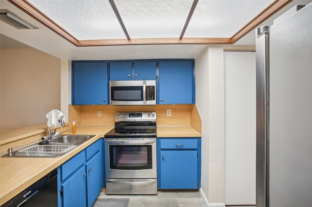 kitchen with appliances with stainless steel finishes, sink, a textured ceiling, and blue cabinetry