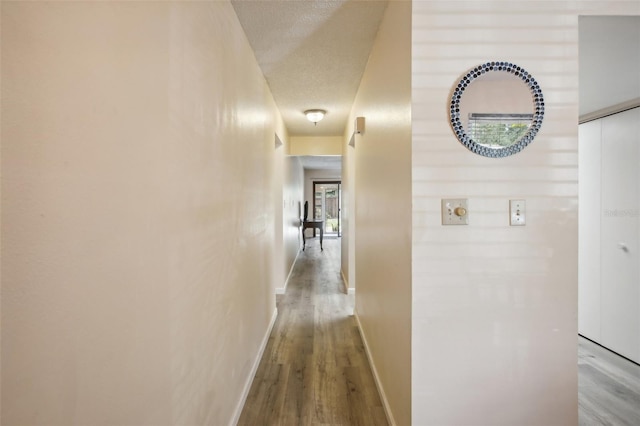 hallway featuring hardwood / wood-style floors and a textured ceiling