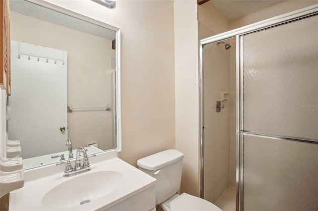 bathroom with toilet, a shower with door, and vanity