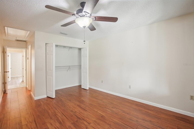 unfurnished bedroom featuring a closet, ceiling fan, hardwood / wood-style flooring, and a textured ceiling