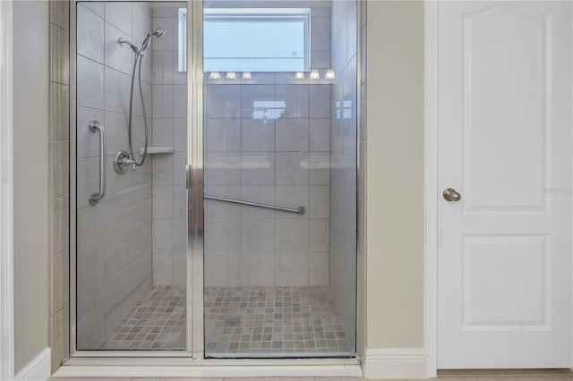 bathroom featuring a shower with door