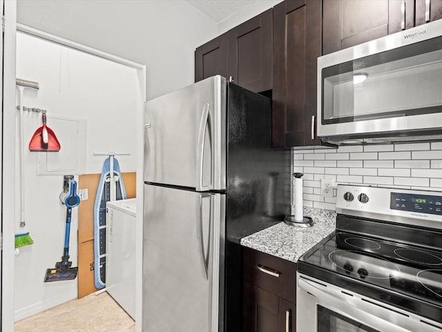 kitchen with light tile patterned floors, appliances with stainless steel finishes, light stone counters, dark brown cabinetry, and tasteful backsplash