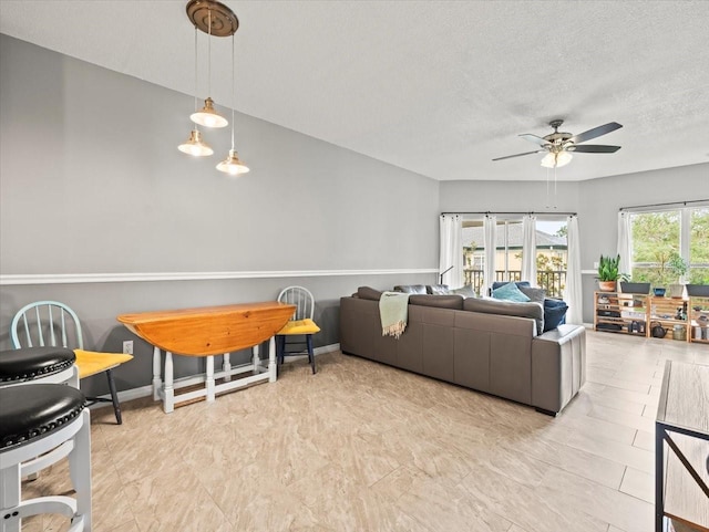 living room featuring a textured ceiling and ceiling fan