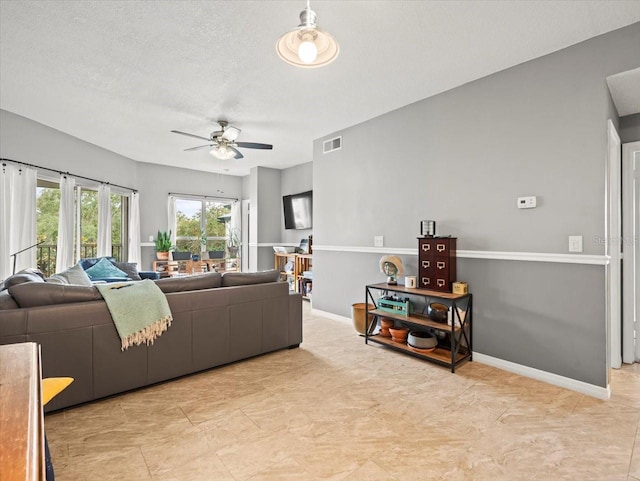 living room featuring a textured ceiling and ceiling fan