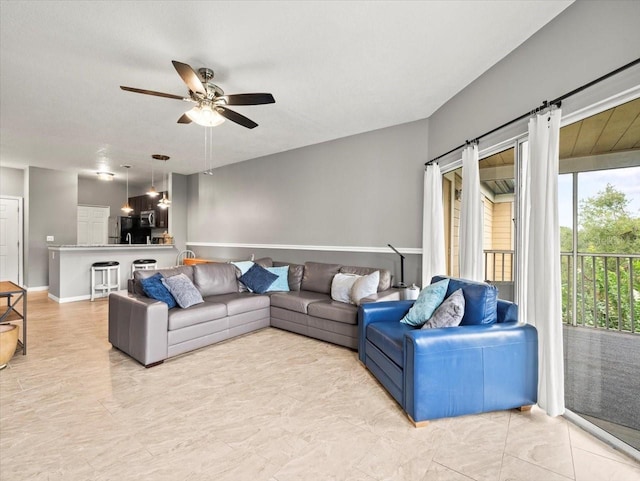 tiled living room with ceiling fan and a barn door