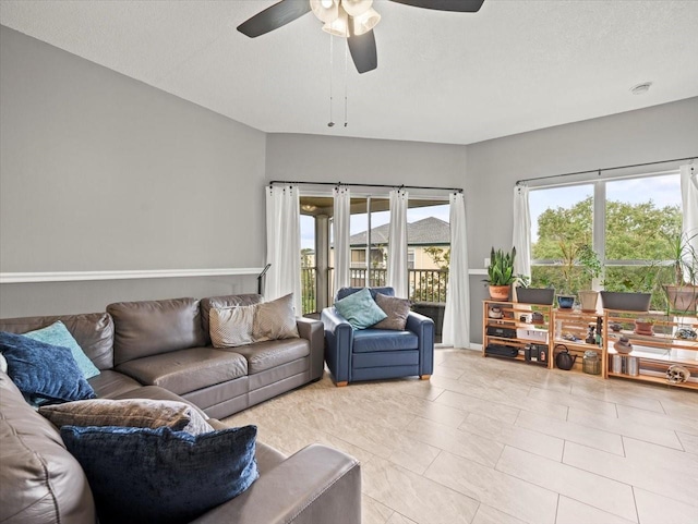 tiled living room with a textured ceiling and ceiling fan