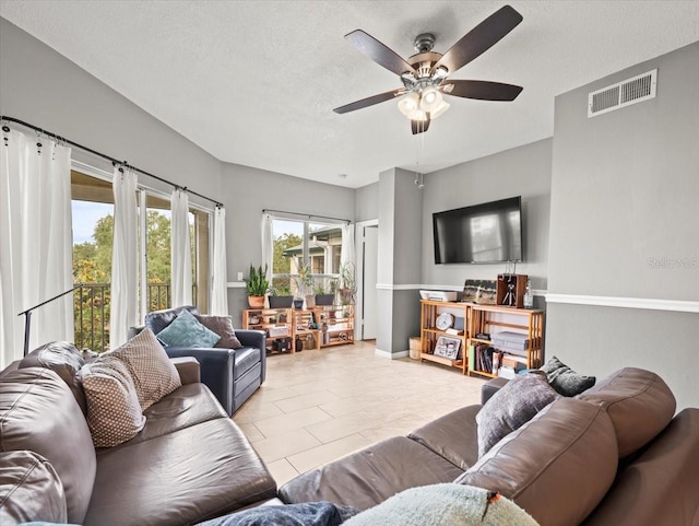 tiled living room with ceiling fan and a textured ceiling