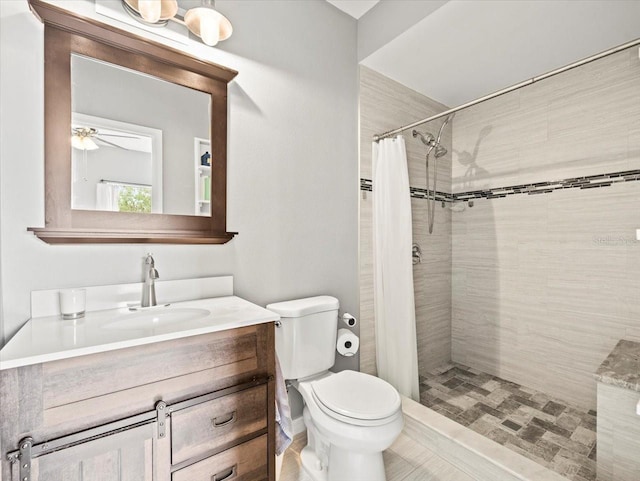 bathroom with walk in shower, toilet, ceiling fan, and vanity