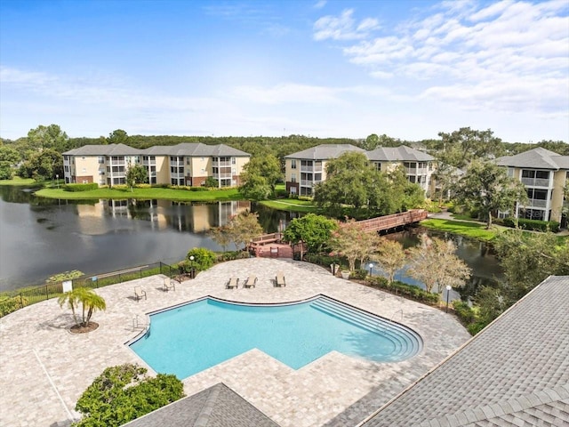 view of swimming pool with a water view and a patio area