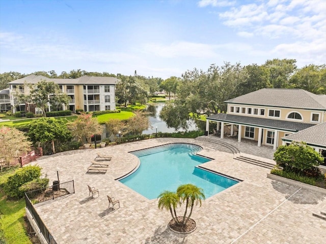 view of swimming pool with a patio area and a water view