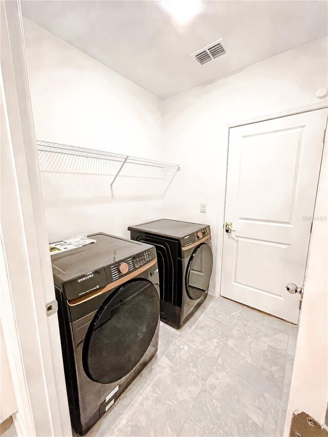 clothes washing area featuring washer and dryer