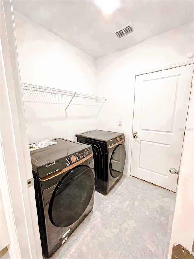 laundry area featuring laundry area, visible vents, and washing machine and clothes dryer