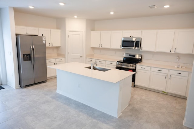 kitchen with sink, white cabinetry, stainless steel appliances, and an island with sink