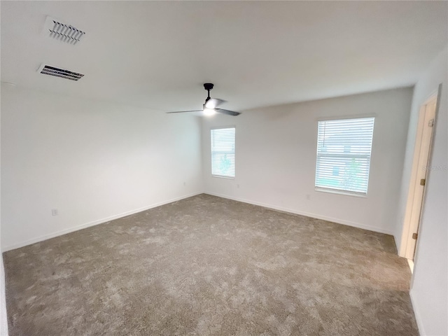 carpeted empty room featuring ceiling fan