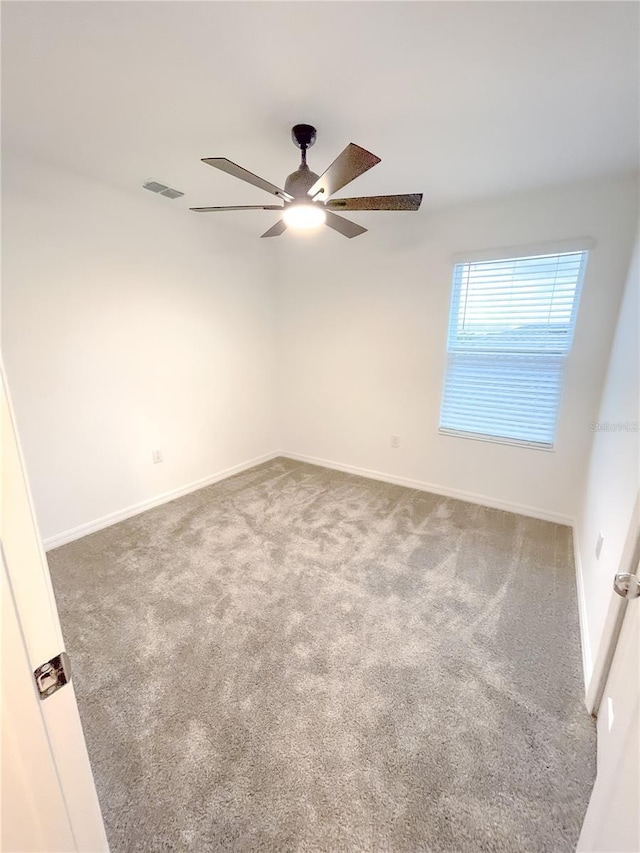 unfurnished room featuring visible vents, baseboards, a ceiling fan, and carpet flooring