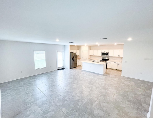 unfurnished living room featuring visible vents and baseboards