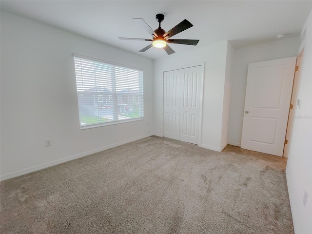 unfurnished bedroom featuring a closet, a ceiling fan, baseboards, and carpet floors