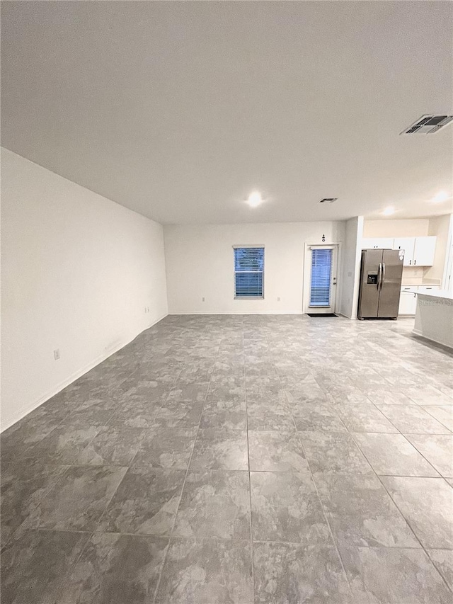 unfurnished living room featuring visible vents