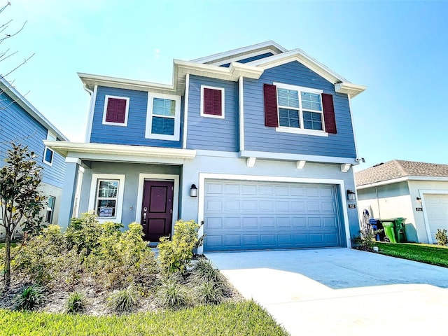 view of front of house with stucco siding, an attached garage, and concrete driveway