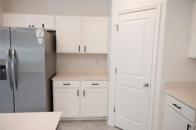 kitchen with white cabinets, light countertops, and stainless steel fridge with ice dispenser