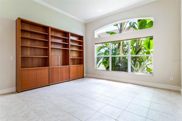 tiled empty room featuring ornamental molding