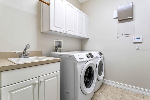 clothes washing area with sink, light tile patterned floors, cabinets, and independent washer and dryer