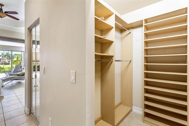 walk in closet with ceiling fan and light tile patterned floors