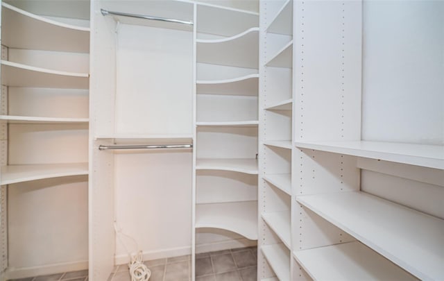 walk in closet with light tile patterned floors