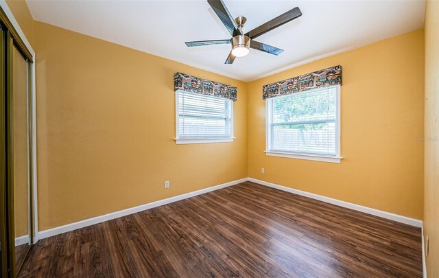 unfurnished bedroom with ceiling fan, a closet, and dark hardwood / wood-style floors