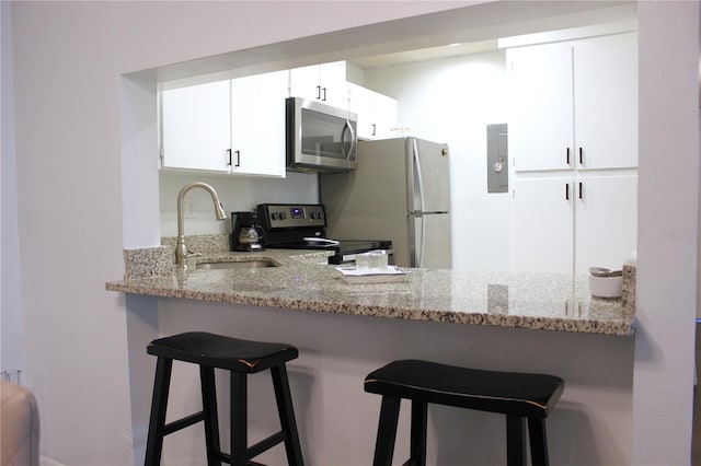 kitchen with white cabinetry, sink, electric range oven, light stone counters, and kitchen peninsula