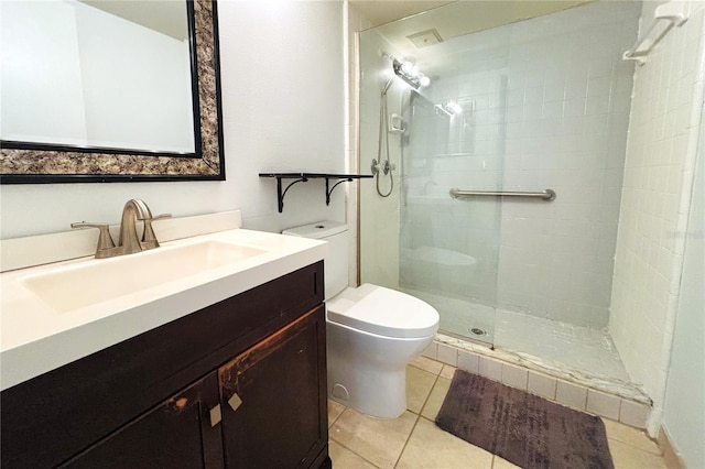 bathroom with tile patterned flooring, vanity, toilet, and tiled shower