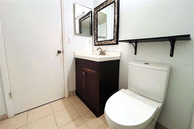 bathroom with tile patterned flooring, vanity, and toilet