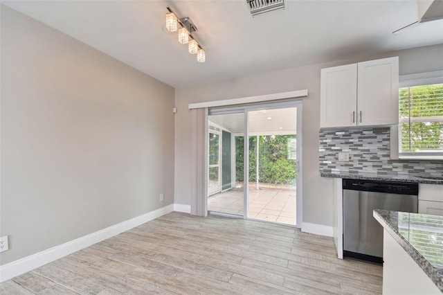 kitchen featuring backsplash, plenty of natural light, stone countertops, and stainless steel dishwasher