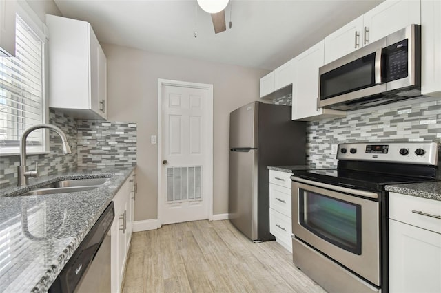 kitchen with stainless steel appliances, sink, white cabinetry, ceiling fan, and light wood-type flooring