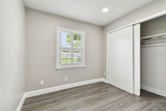 unfurnished bedroom featuring hardwood / wood-style floors and a closet