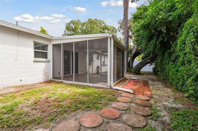 rear view of property with a sunroom and a patio