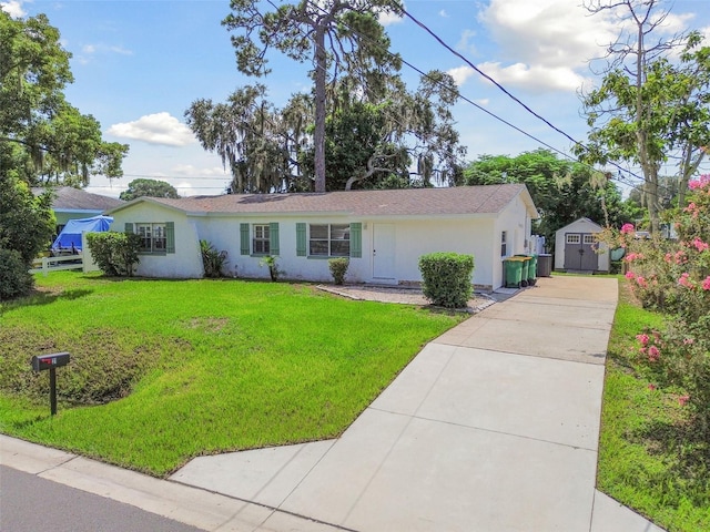 ranch-style home featuring a storage shed and a front yard